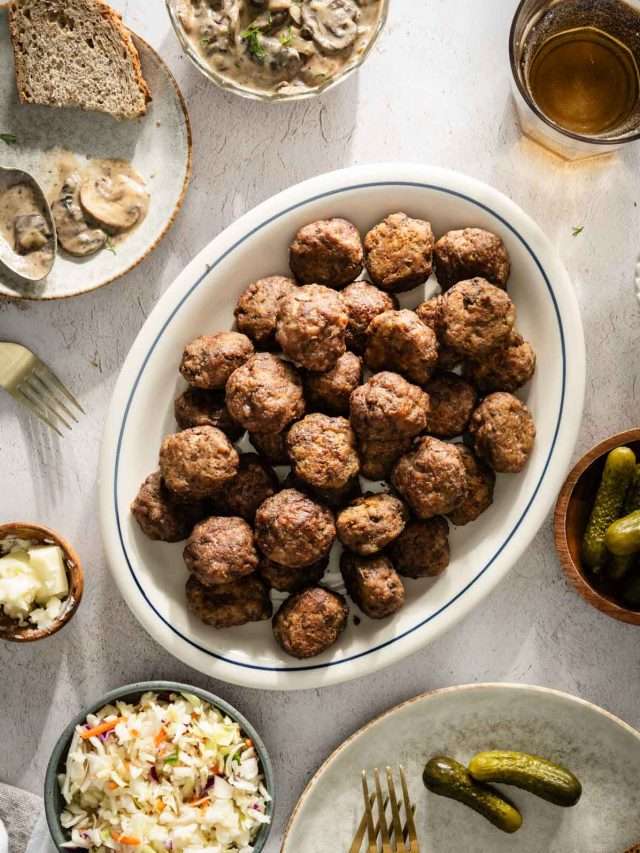 Meatballs on a serving platter; small side dishes around