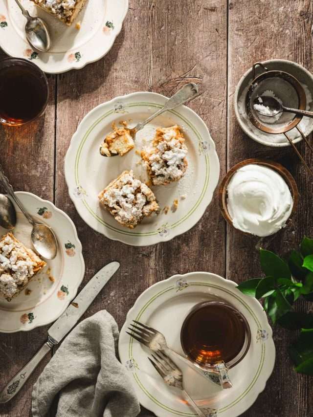 szarlotka on serving plates, tea, bowl with powdered sugar, bowl with whipped toppin